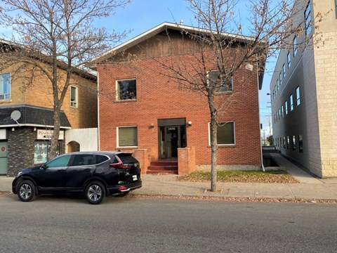 a black car parked in front of a brick building